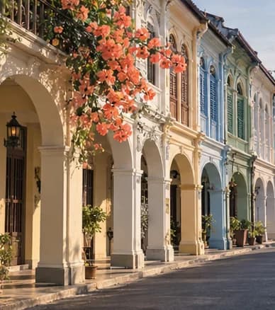 A row of Sino-Portuguese shophouses with arched walkways, pastel facades and wooden shutters
